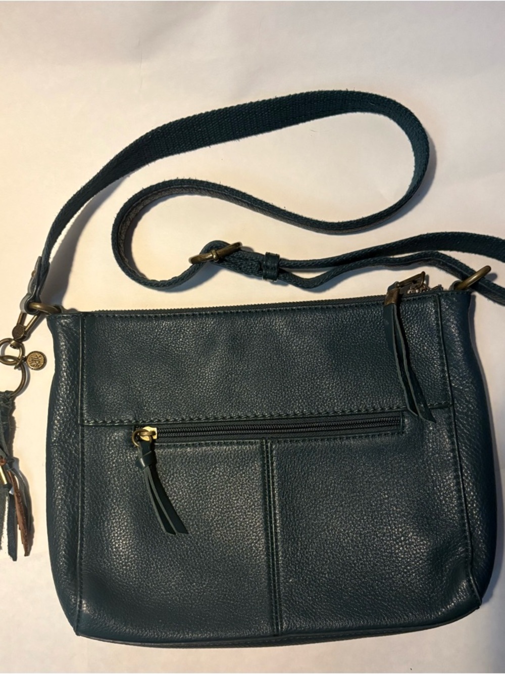 The Sak Teal Leather Crossbody Bag with fun feather accent fob